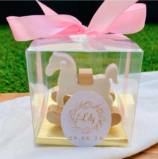 Découvrez le somptueux Coffret Presti Biscuit, présenté dans un élégant emballage orné d'un ruban de soie de la couleur de votre choix. Ce coffret luxueux contient quatre carrés de chocolat finement confectionnés, accompagnés d'un cheval à bascule en bois magnifiquement sculpté. Personnalisez ce cadeau d'exception avec une étiquette portant le nom et la date de votre choix, pour une touche de raffinement unique.