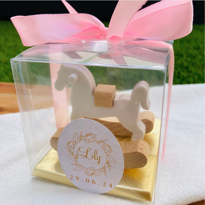 Découvrez le somptueux Coffret Presti Biscuit, présenté dans un élégant emballage orné d'un ruban de soie de la couleur de votre choix. Ce coffret luxueux contient quatre carrés de chocolat finement confectionnés, accompagnés d'un cheval à bascule en bois magnifiquement sculpté. Personnalisez ce cadeau d'exception avec une étiquette portant le nom et la date de votre choix, pour une touche de raffinement unique.