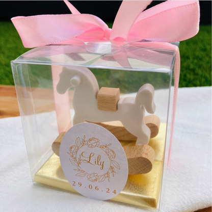 Découvrez le somptueux Coffret Presti Biscuit, présenté dans un élégant emballage orné d'un ruban de soie de la couleur de votre choix. Ce coffret luxueux contient quatre carrés de chocolat finement confectionnés, accompagnés d'un cheval à bascule en bois magnifiquement sculpté. Personnalisez ce cadeau d'exception avec une étiquette portant le nom et la date de votre choix, pour une touche de raffinement unique.