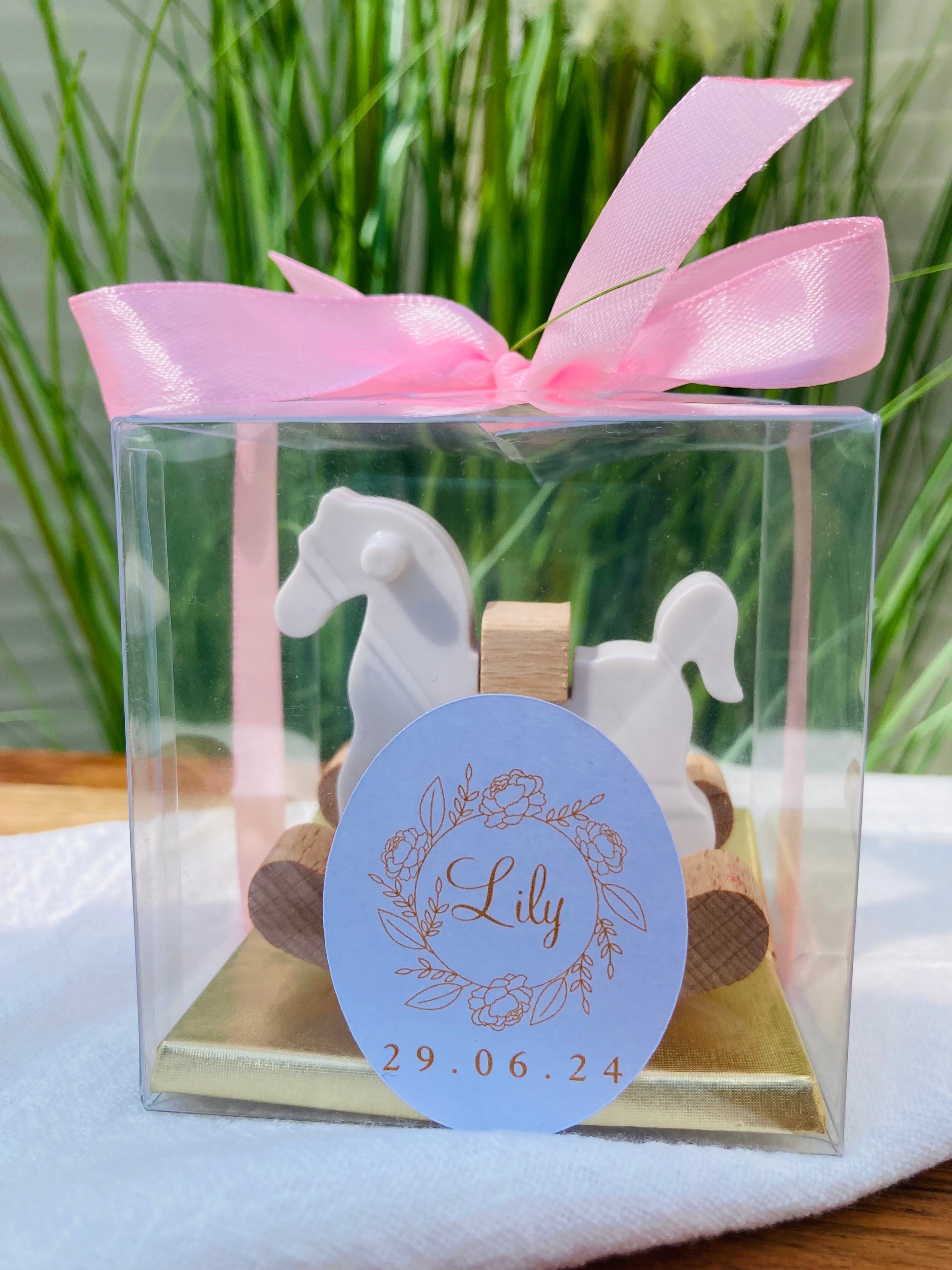 Découvrez le somptueux Coffret Presti Biscuit, présenté dans un élégant emballage orné d'un ruban de soie de la couleur de votre choix. Ce coffret luxueux contient quatre carrés de chocolat finement confectionnés, accompagnés d'un cheval à bascule en bois magnifiquement sculpté. Personnalisez ce cadeau d'exception avec une étiquette portant le nom et la date de votre choix, pour une touche de raffinement unique